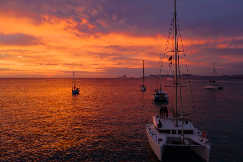 Aerial view from drone on boats shipping in sea, sunset. Yachting with a dramatic sunset as backdrop